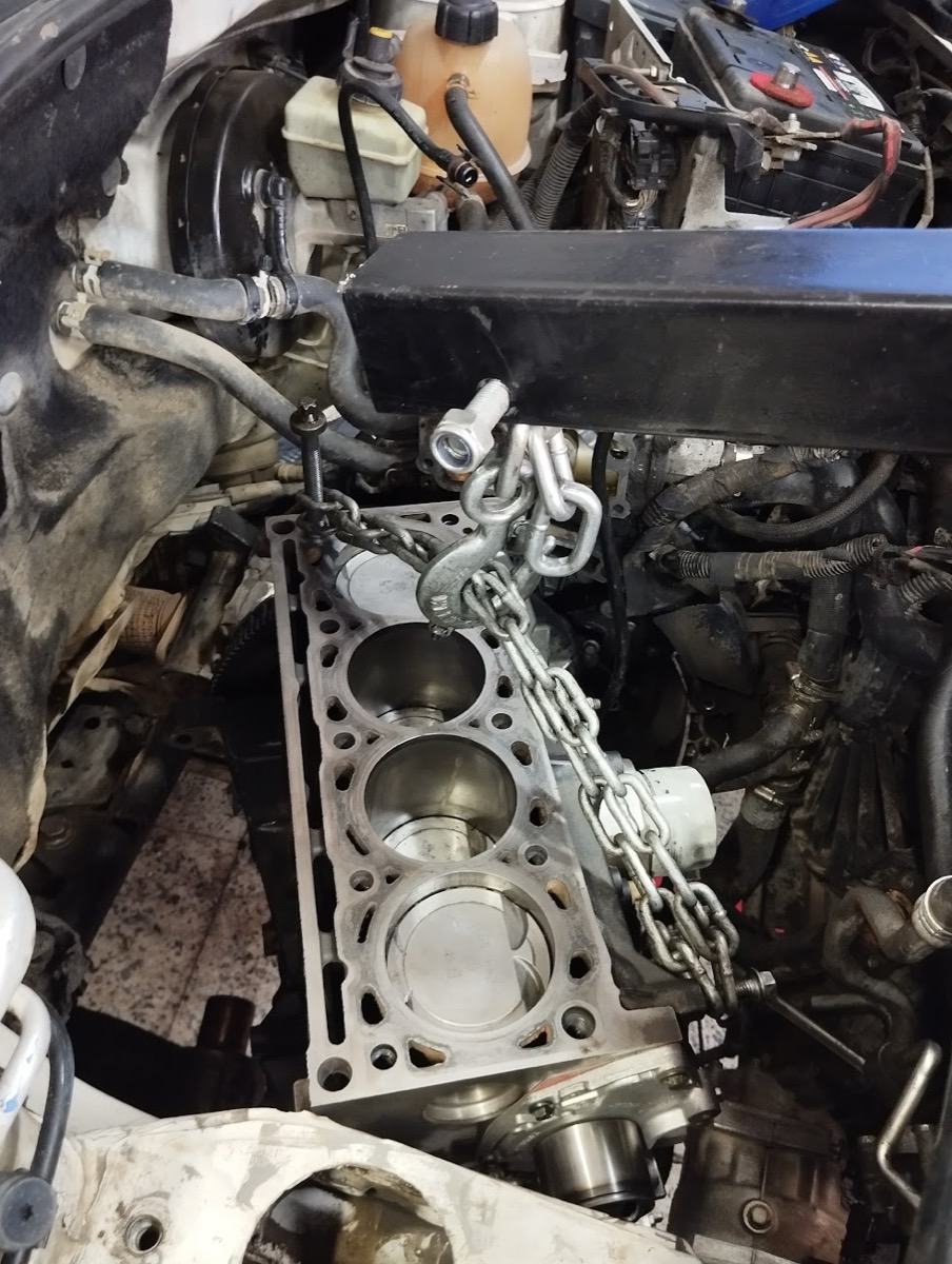 Bloque de motor en reparación con grúa de taller